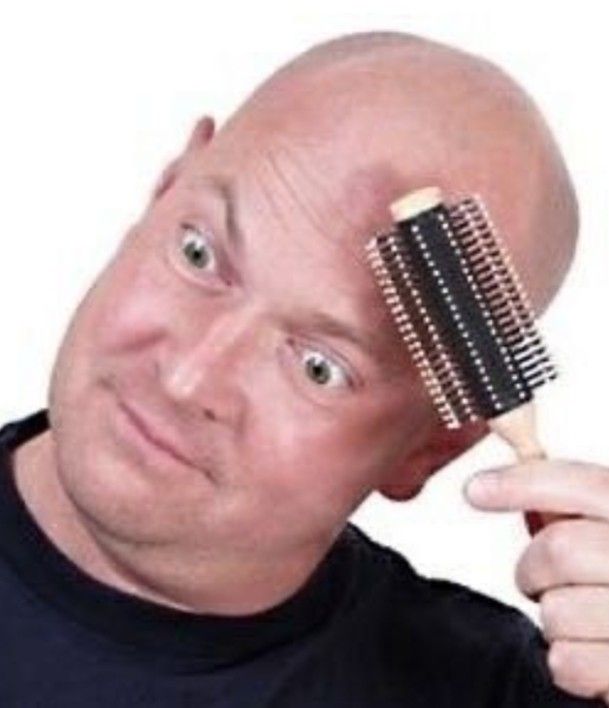 Man combing bald head with a hairbrush